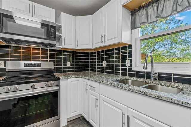 904 E Golf Hill Dr, Excelsior Springs, MO 64024 - kitchen with appliances with stainless steel finishes, a sink, white cabinetry, and tasteful backsplash