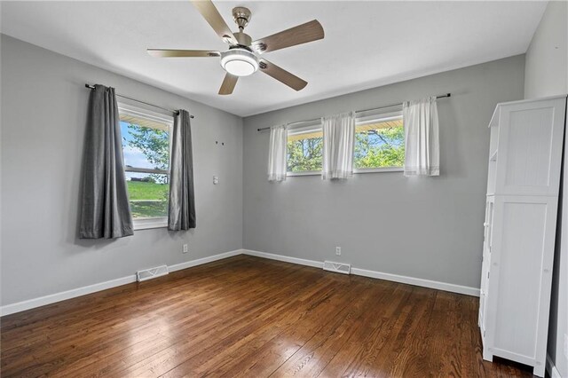 904 E Golf Hill Dr, Excelsior Springs, MO 64024 - unfurnished room featuring healthy amount of natural light, dark wood-type flooring, ceiling fan, and baseboards