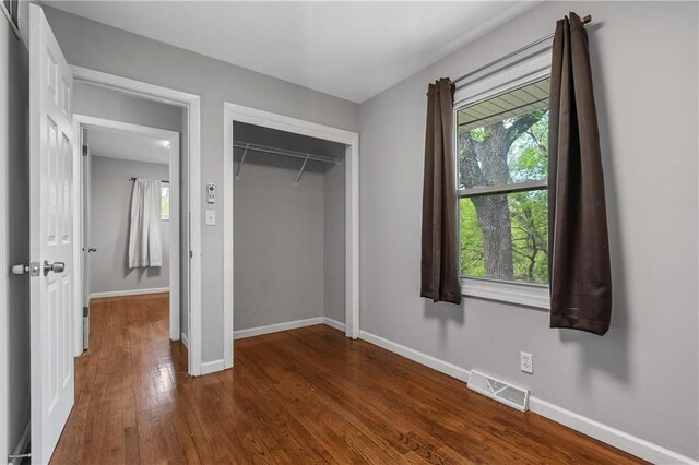 904 E Golf Hill Dr, Excelsior Springs, MO 64024 - unfurnished bedroom featuring dark wood-style flooring, baseboards, and a closet