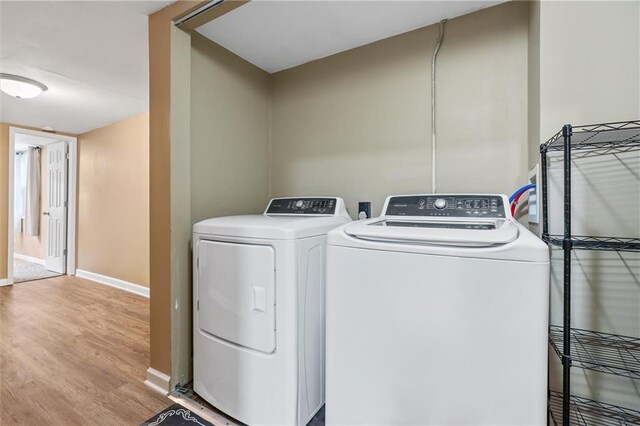 904 E Golf Hill Dr, Excelsior Springs, MO 64024 - laundry room featuring washing machine and dryer, wood finished floors, and baseboards