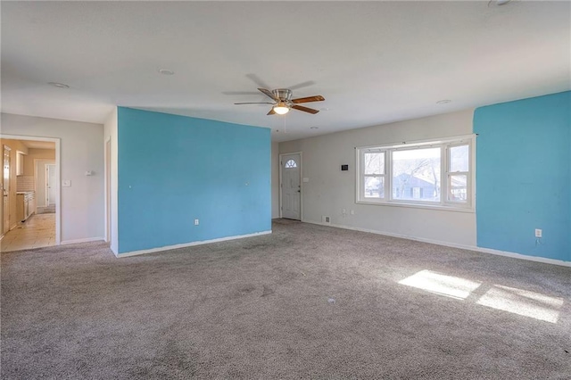 unfurnished room featuring ceiling fan, carpet floors, and baseboards