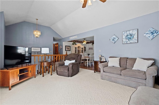 living area featuring lofted ceiling, carpet floors, and ceiling fan with notable chandelier