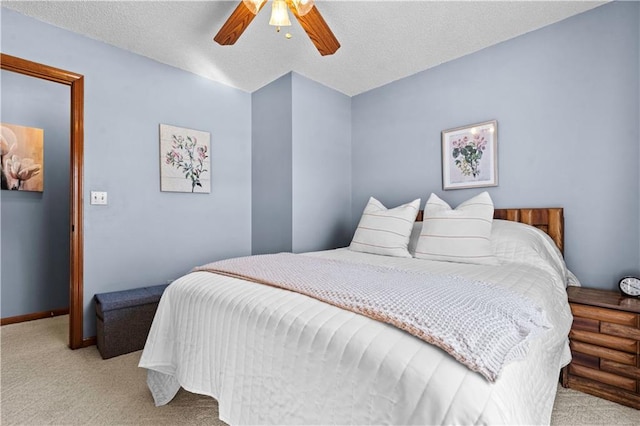 bedroom with light carpet, ceiling fan, baseboards, and a textured ceiling