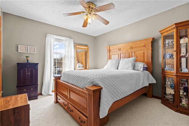 bedroom with light carpet, a textured ceiling, and a ceiling fan