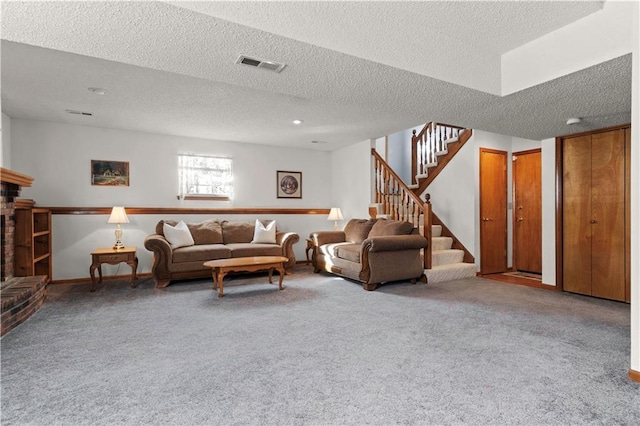 carpeted living area with visible vents, a brick fireplace, a textured ceiling, baseboards, and stairs