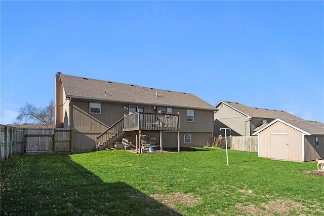 rear view of house with an outbuilding, a fenced backyard, stairway, a lawn, and a shed