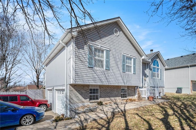 view of property exterior with fence, driveway, and an attached garage