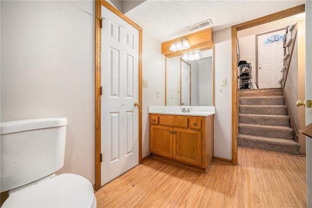 bathroom featuring visible vents, toilet, and wood finished floors