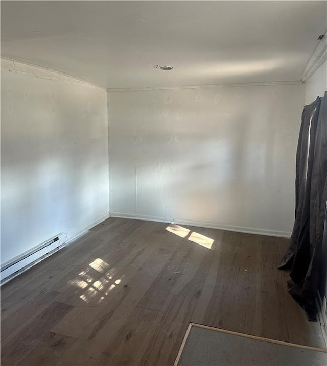 empty room with dark wood-style flooring and baseboard heating