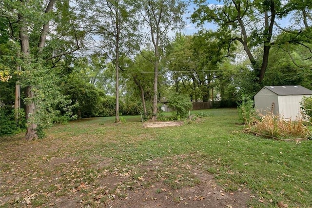 view of yard with a shed, fence, and an outdoor structure