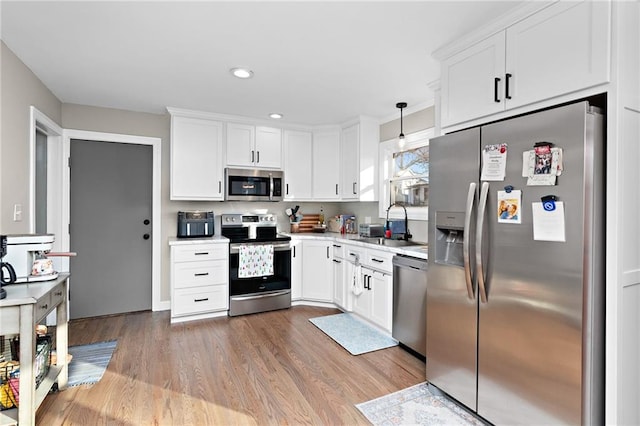 kitchen featuring white cabinets, appliances with stainless steel finishes, and light countertops