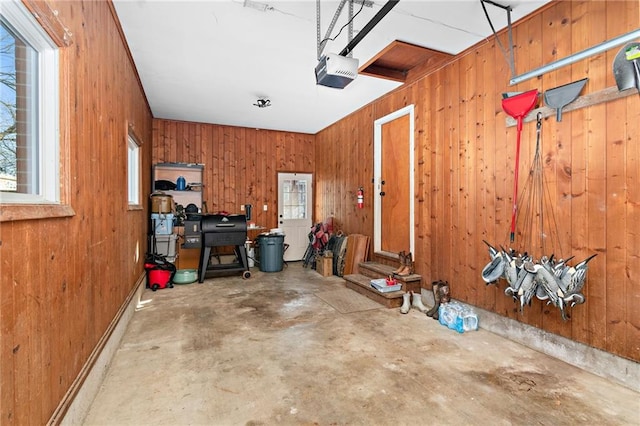 garage featuring a garage door opener and wood walls