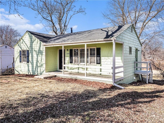 ranch-style house with a porch and roof with shingles