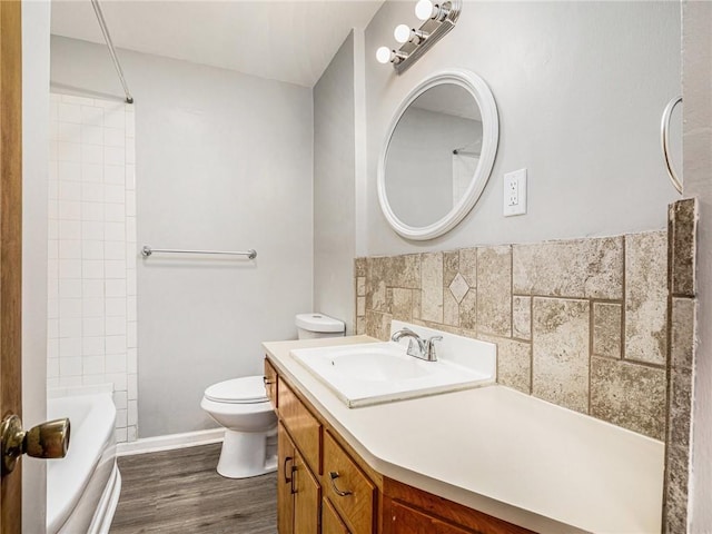 bathroom featuring toilet, vanity, bathing tub / shower combination, and wood finished floors