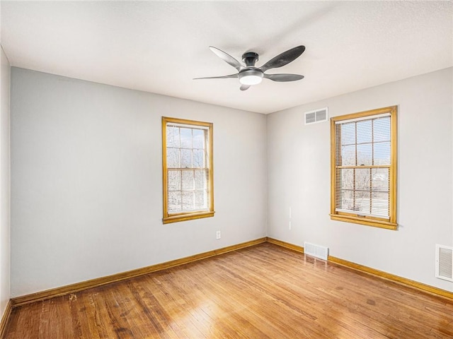 spare room with light wood-style flooring, baseboards, and visible vents