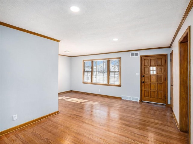 entrance foyer with visible vents, light wood-style flooring, a textured ceiling, and baseboards