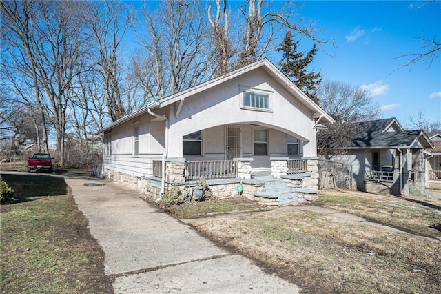 bungalow-style house with covered porch and stucco siding