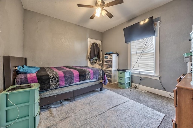 carpeted bedroom with a ceiling fan and baseboards