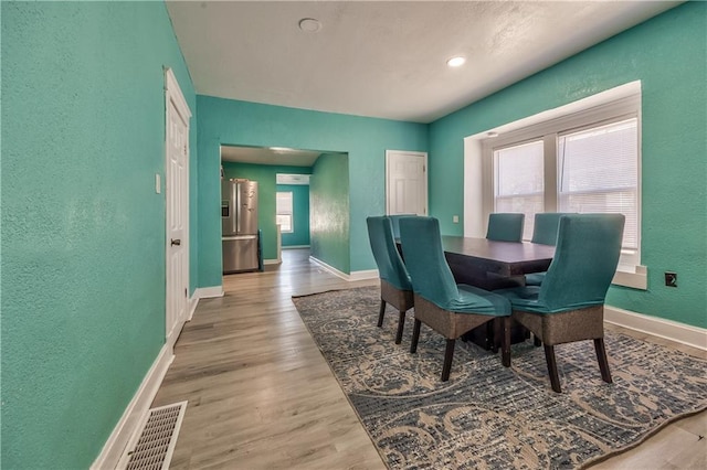 dining area featuring visible vents, plenty of natural light, baseboards, and wood finished floors