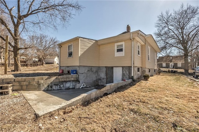 view of side of property with a patio and a chimney