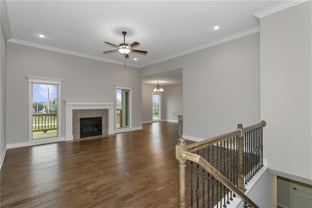 unfurnished living room featuring a healthy amount of sunlight, baseboards, dark wood-type flooring, and a tile fireplace