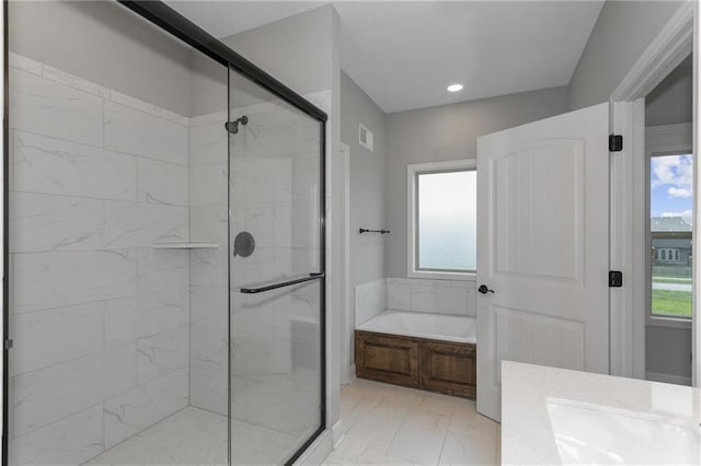 bathroom featuring marble finish floor, a stall shower, plenty of natural light, and a bath