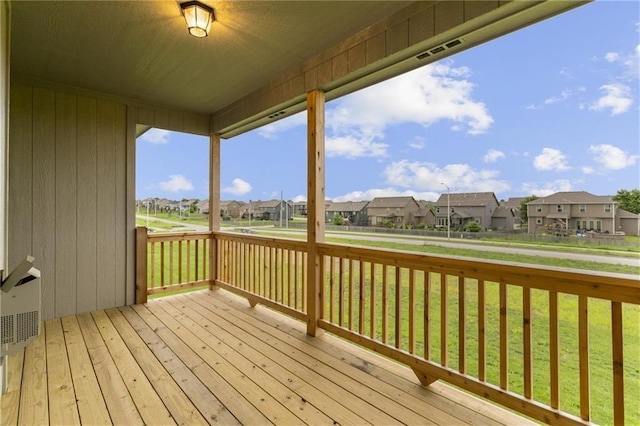 wooden terrace featuring a residential view and a lawn