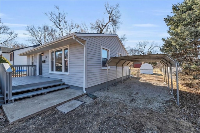 view of side of property with a carport, driveway, and a wooden deck