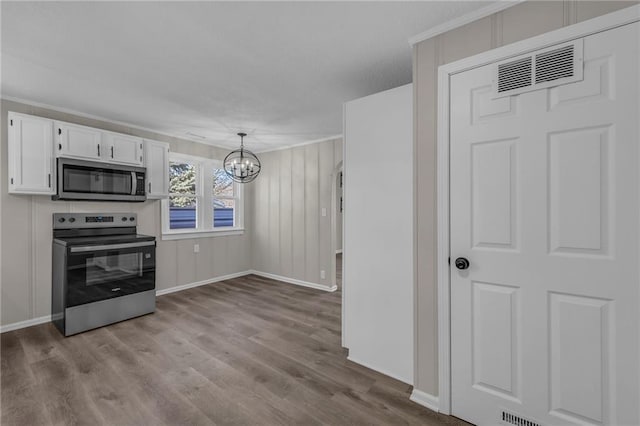 interior space featuring a chandelier, wood finished floors, visible vents, and baseboards