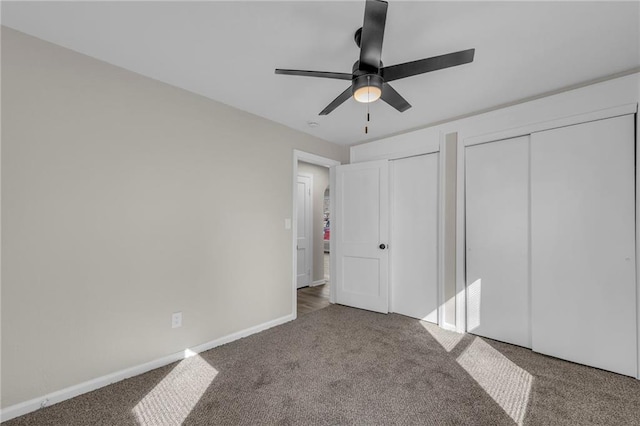 unfurnished bedroom with carpet floors, ceiling fan, baseboards, and multiple closets