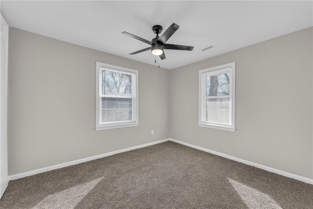 unfurnished room with carpet floors, a ceiling fan, visible vents, and baseboards