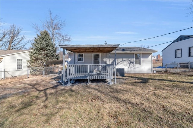 rear view of house featuring central AC unit, fence, a lawn, and a detached carport