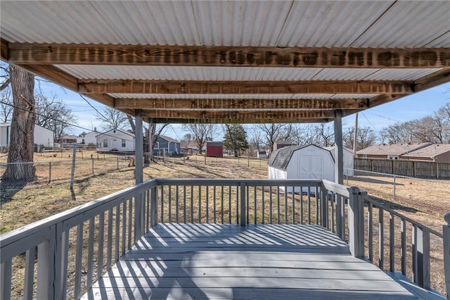 wooden terrace with a shed, a residential view, and an outdoor structure