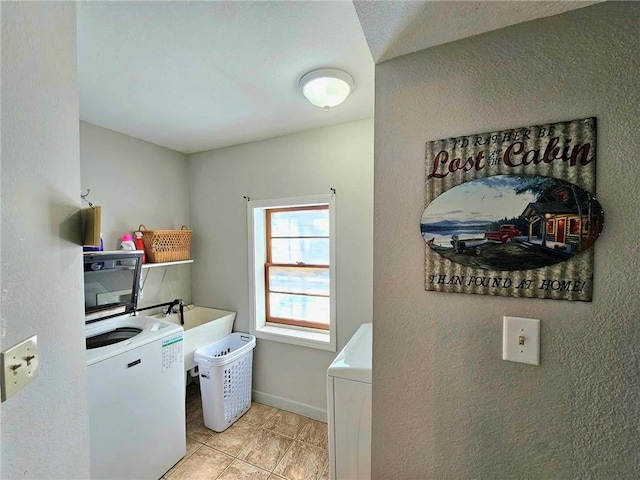 clothes washing area featuring light tile patterned flooring, a sink, washer / dryer, laundry area, and baseboards