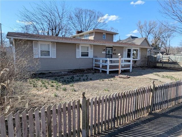 view of front of house featuring a chimney and fence private yard