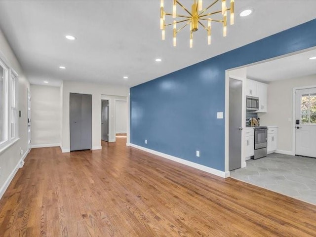 unfurnished living room featuring light wood finished floors, recessed lighting, and baseboards