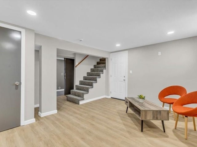 living area with recessed lighting, baseboards, stairway, and light wood finished floors