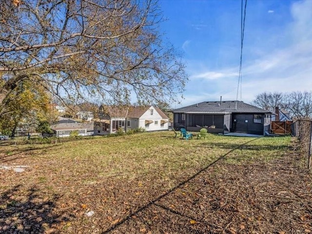 view of yard featuring fence and a sunroom