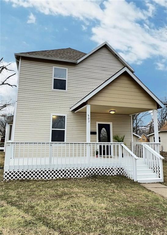 traditional home with covered porch and a front lawn