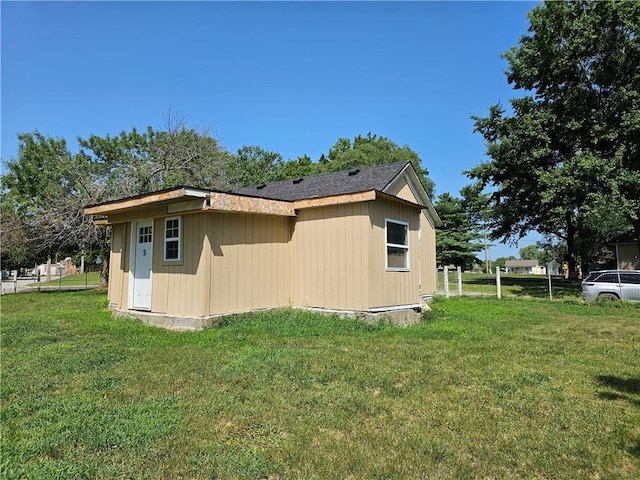 view of side of property with a lawn and fence