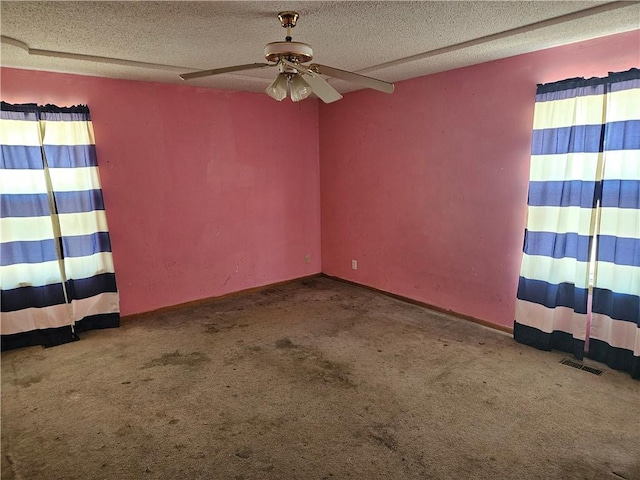 carpeted empty room with a textured ceiling, visible vents, and a ceiling fan