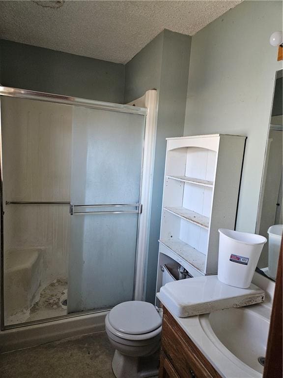 full bathroom featuring toilet, vanity, a shower stall, and a textured ceiling