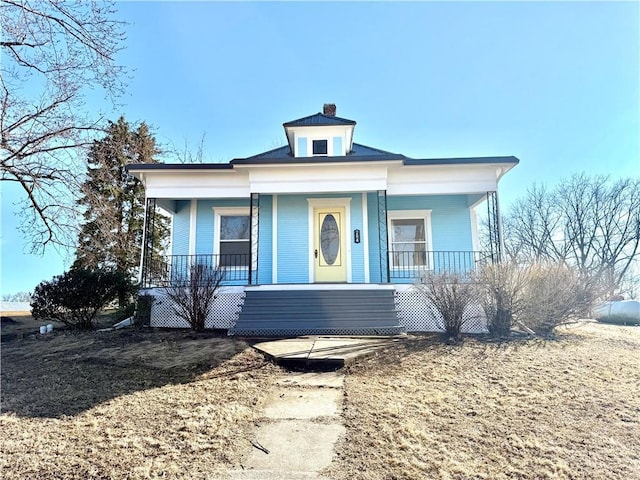 bungalow with a porch and a chimney