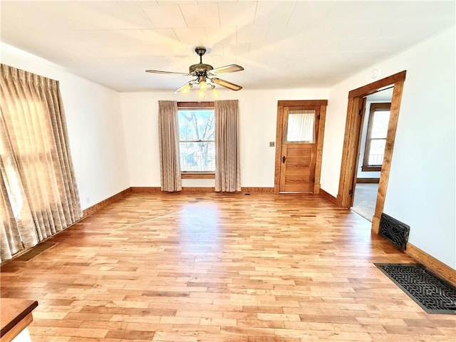 spare room with light wood-type flooring, visible vents, and a ceiling fan