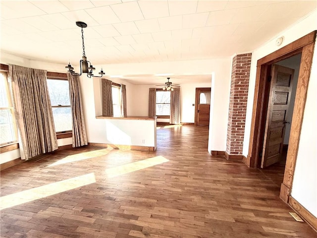 interior space featuring ceiling fan with notable chandelier, plenty of natural light, and wood finished floors