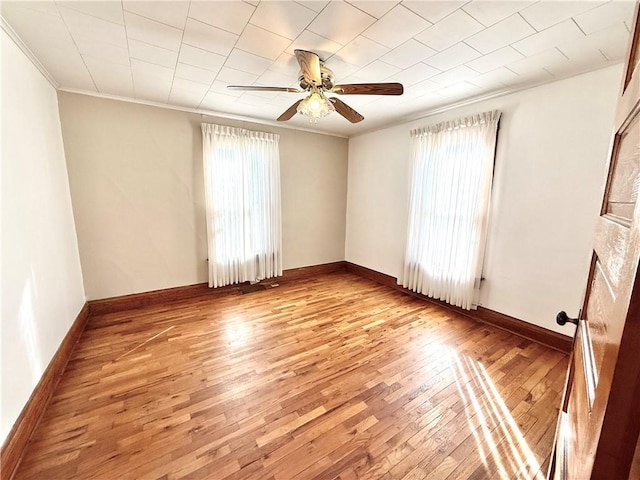 unfurnished room featuring ornamental molding, plenty of natural light, and hardwood / wood-style flooring