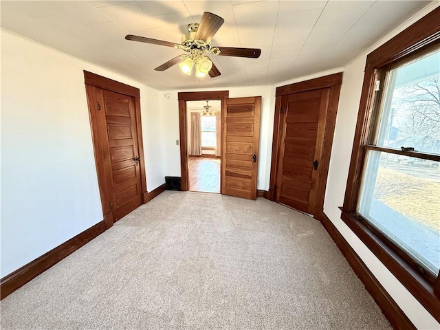 unfurnished bedroom with carpet floors, multiple windows, and baseboards