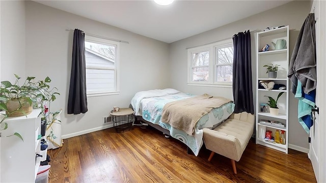 bedroom with visible vents, baseboards, and wood finished floors