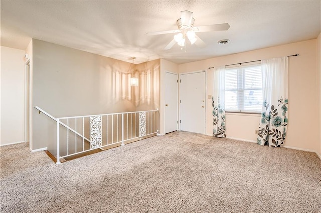 empty room with baseboards, carpet, visible vents, and a textured ceiling