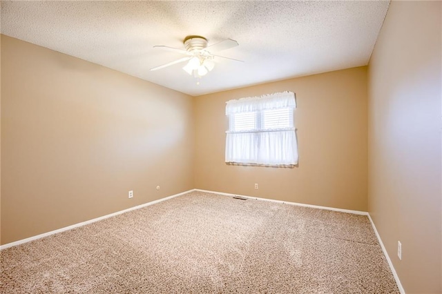 unfurnished room featuring ceiling fan, a textured ceiling, carpet flooring, visible vents, and baseboards